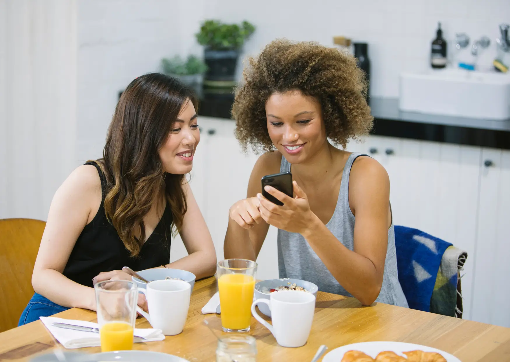 a picture of a person showing her friend something on the phone