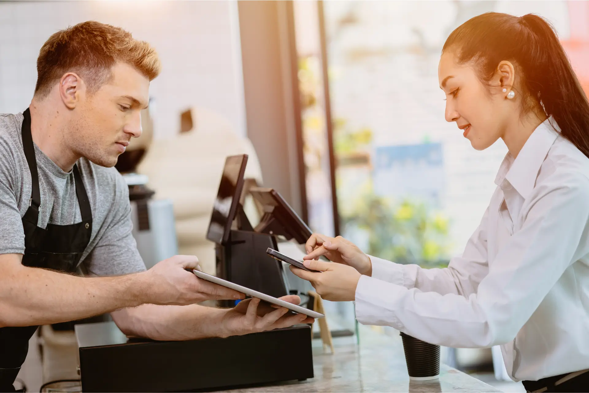 a cashier scanning a customer's phone